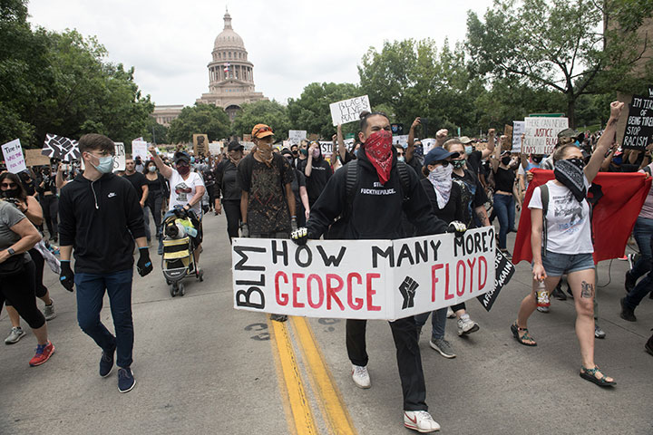 Protesters march down Congress Avenue in front of the Texas State Capitol 
