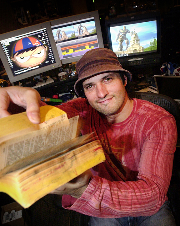 Portrait of American filmmaker and composer Robert Rodriguez holding a flip book he created as a child in his home studio.