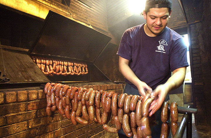 A Gonzales Food Market pitmaster hangs sausage