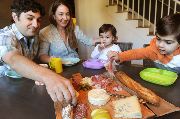 John and Kendall Antonelli eat charcuterie at home with their children Elia and Everett