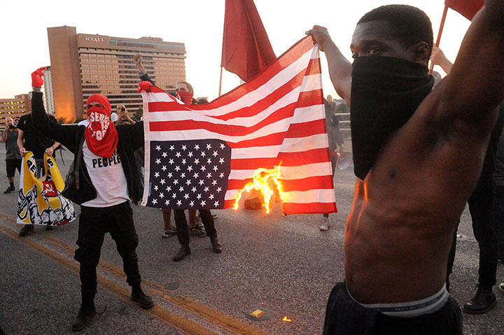 Protesters burn an American flag during a May Day demonstration