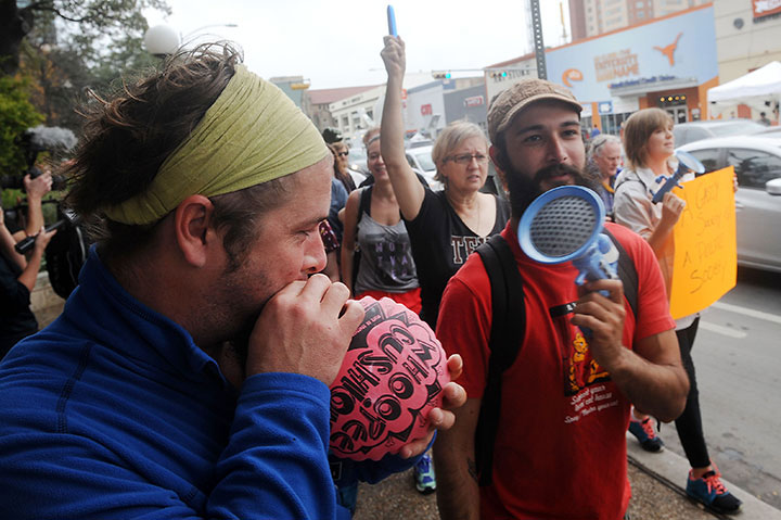 Counter-protesters use noisemakers to mock an open carry