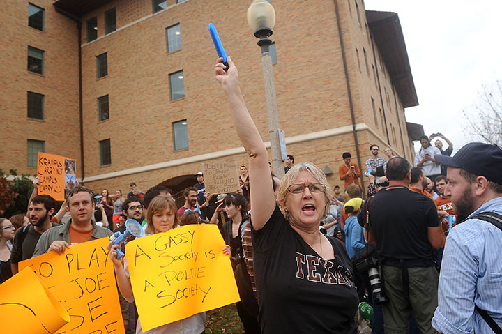 A counter-protester holds a dildo during an open carry demonstration. The action is associated with other pro-gun control protests at UT called 'Cocks Not Glocks.'